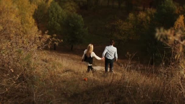 Hombre y mujer se abrazan viendo la vieja ciudad sobre los árboles de otoño — Vídeos de Stock