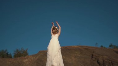 Uzun, beyaz elbiseli ve kafasındaki çelenk ile güzel bir kadın onu tatil sırasında dağlarda barış zaman zevk