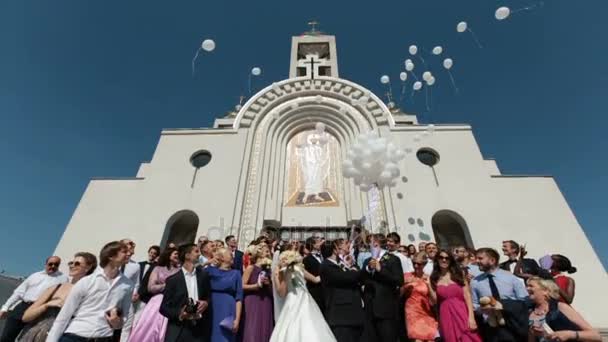 Recién casados y sus invitados lanzan globos al aire — Vídeos de Stock