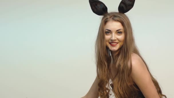 Verleidelijke vrouw met oren van het konijn werpt een bijl — Stockvideo