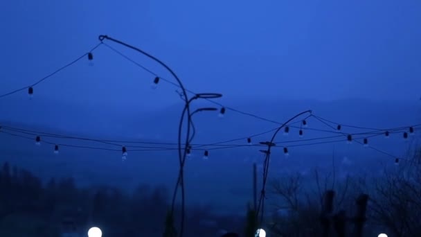 The horizontal view of the little light bulbs hanging in the mountains in the evening. — Stock Video
