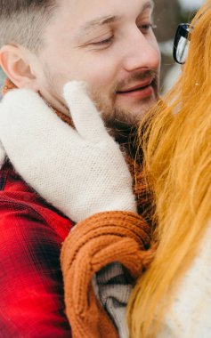 Hassas yakın çekim yakışıklı adamın yüzünü dokunan kırmızı baş kadın portresi.