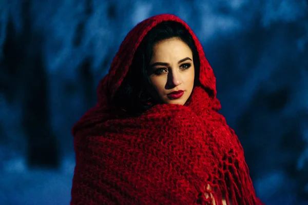Atractiva novia con el pelo negro se envuelve en la bufanda de punto rojo. Pasar la noche en el bosque nevado . — Foto de Stock