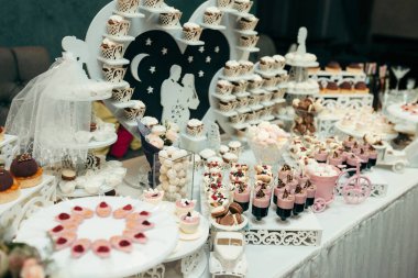 Yan çekim düğün tablo tatlı pembe beyaz duymak çubuğu çift aşk tatlı şekerler jöle Macarons Cupcakes.