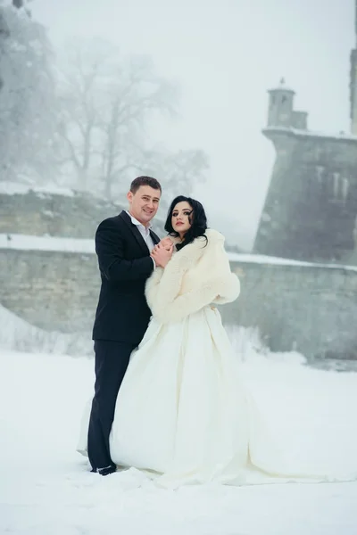 Comprimento total vertical tiro recém-casados casamento abraçando neve inverno natal novo ano segurando as mãos ao ar livre . — Fotografia de Stock