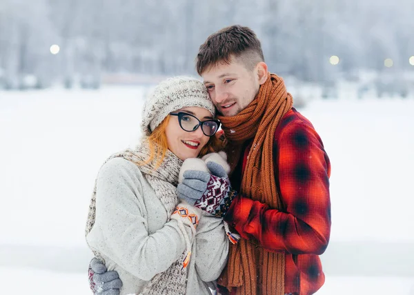 Beau couple amoureux est câlin sur la prairie enneigée. Le portrait extérieur d'hiver à mi-longueur . — Photo
