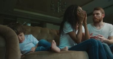 Küçük oğlu cep telefonda oynamak ve koltukta yalan multirace aile çatışma yaşıyor. Duygusal Afro-Amerikan anne.