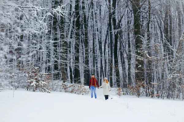 Filmagem completa do casal amoroso feliz de mãos dadas e correndo ao longo da floresta nevada fofa. Tempo de Natal . — Fotografia de Stock