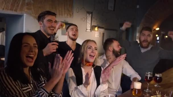 Los amigos felices están pasando su tiempo libre animando a su equipo de fútbol favorito y haciendo brindis por su victoria en el pub . — Vídeos de Stock