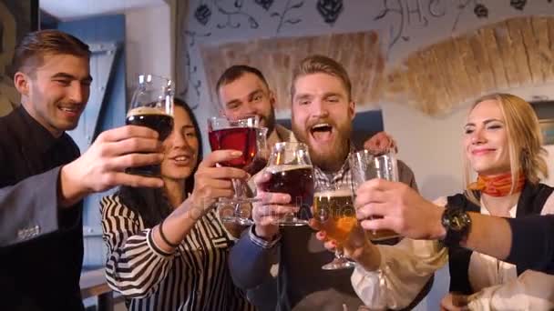 Os amigos estão se divertindo celebrando o evento importante, clicando em copos com cerveja no bar. Retrato de close-up . — Vídeo de Stock