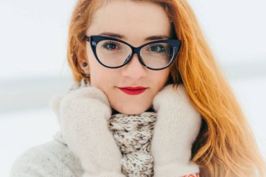 Derin görüş olan çekici kırmızı baş kadın gözlük takıyorum. Kar yağışı sırasında kırsalında vakit.