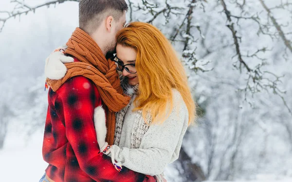 Usulca ormanda kar yağışı sırasında sarılma hassas sevgi dolu çift yatay yakın çekim portre.