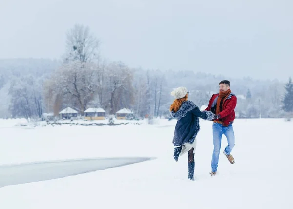爱的情侣在雪地上跳舞, 在雪覆盖的草地上尽情玩乐. — 图库照片