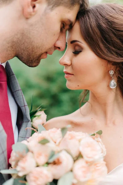 Ніжний дотик ніжної весільної пари в зеленому саду — стокове фото