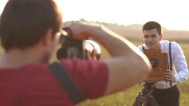 Vintage fotoğraf çekmek fotoğrafçı arkadan görünüm damat eski fotoğraf makinesi ile giyinmiş. Alan konumu.
