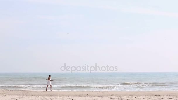 A mulher está correndo, pulando e se divertindo na praia . — Vídeo de Stock