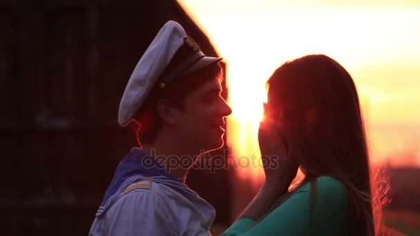 La vista de cerca de la feliz pareja sonriente en el fondo de la puesta de sol roja . — Vídeos de Stock