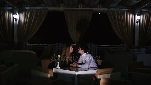 The romantic view of the kissing couple in the dark restaurant. — Stock Video