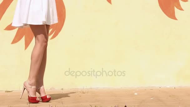 El caminar de la mujer en tacones altos cerca de la pared amarilla. La vista de cerca . — Vídeos de Stock