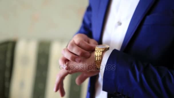Stylové oblečení ženicha v svatební oblek je twitting ruky hodinky. Detailní zobrazení. — Stock video