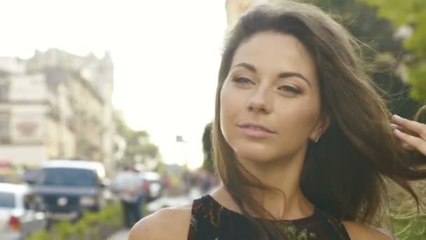 La vista de cerca de la encantadora chica ordenando el cabello durante su paseo por el centro . — Vídeos de Stock