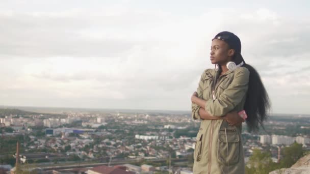 Ritratto laterale della giovane ragazza africana attraente rilassante e godendo della vista panoramica sulla città. 4k . — Video Stock