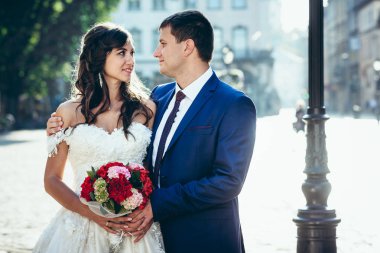 Sarılma ve diğer sokak şehirdeki eadh gözüyle bakarak mutlu yeni evli çiftin hassas portre.