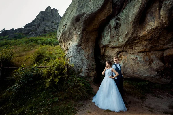 Dağlarda mutlu yeni evliler tam uzunlukta açık portresi. Damat geline arıyor. — Stok fotoğraf