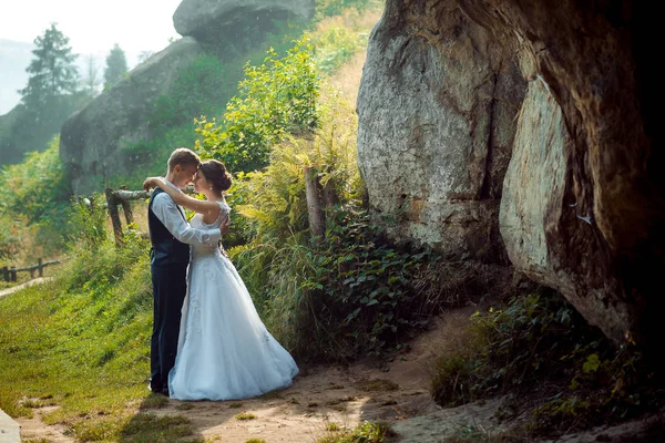 Romantik açık hava düğün portre. Şık yeni evliler sarılma ve birbirlerine güneşli Dağları üzerinde kafa kafaya ayakta. — Stok fotoğraf