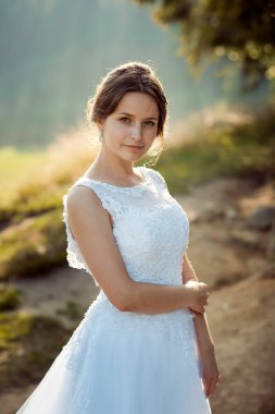 Doğal makyaj güneşli ormanda poz ile büyüleyici genç esmer gelin.