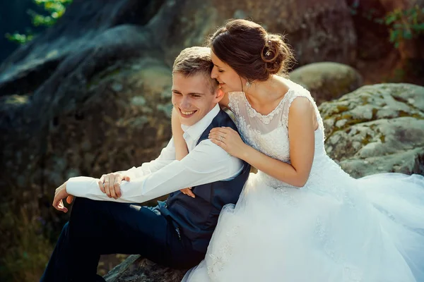 Einfühlsames Porträt des schönen, fröhlichen Brautpaares, das sich sanft auf dem Felsen umarmt. — Stockfoto