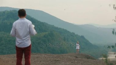 Harita tutarak ve dağ kenarında duran sarışın kadın bakarak kayıp Gezgin arkadan görünüm. Helikopter görünümü.