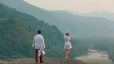 Yakın çekim geri sarışın turist geliyor ve konuşma başlangıç harita ile gelen adam tarihinde dron'un görüntüleyin. Dağ konumu.