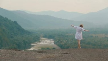 Güzel sarışın Gezgin yavaş yavaş dağlar RIM yürüyüş kaldırdı elleriyle arkadan görünüm. Drone görünümü.