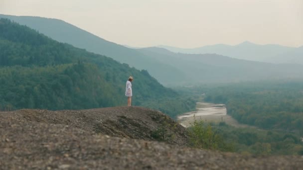 Widok turysty Blondynka szczęśliwie taniec na skraju gór i ciesząc się krajobraz z tyłu. — Wideo stockowe