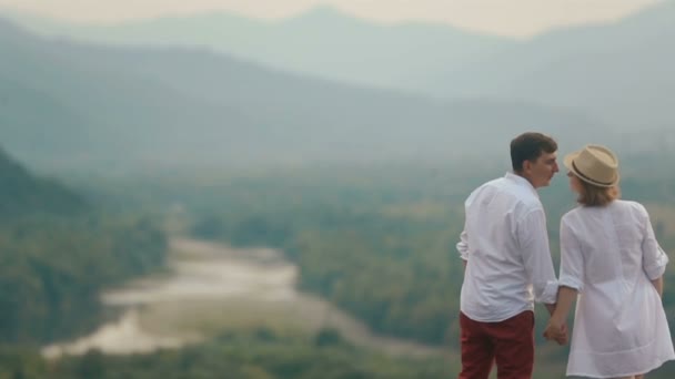 Close-up visão traseira do drone sobre o casal beijando alegre no fundo da bela paisagem do rio e florestas . — Vídeo de Stock