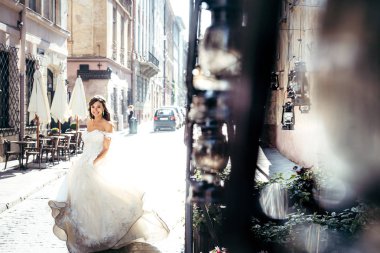 Tam uzunlukta düğün atış gelinin uzun elbise güneşli sokakta yuvarlak iplik sevimli sevimli esmer.