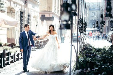 Güzel yeni evli çift eğlenceli güneşli eski şehir sokakta dans ederken yaşıyor.