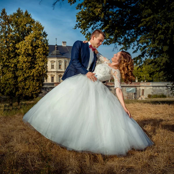 Güzel giyimli mutlu yeni evliler kalenin arka plan dans ediyor. — Stok fotoğraf