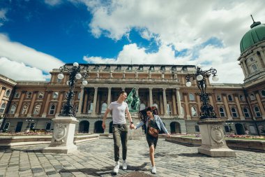Neşeyle countryard Buda Castle Kraliyet Sarayı Budapeşte, Macaristan, boyunca aşık el çekici çift tarafından yürüyüş.