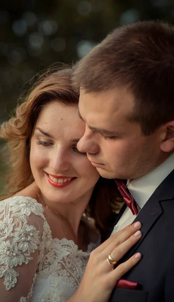 Nahaufnahme des sensiblen Hochzeitsportraits des hübsch lächelnden Brautpaares, das sich sanft umarmt. — Stockfoto