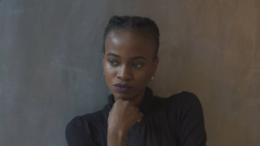 Mor ruj ve pigtails Afro-Amerikan kadın bir kenara gri arka plan arıyor sakin sevimli izole.