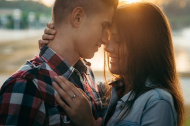 Yakın çekim sırasında susnet hassas romantik portre. Güzel genç gülümseyen çift yavaşça sarılma ve burun sürtme.
