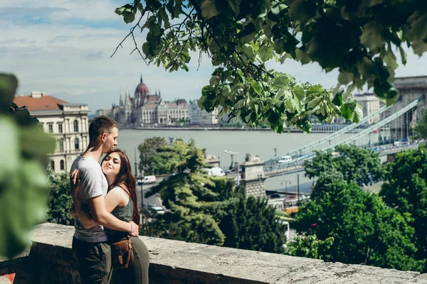 Genç ve güzel sevgi dolu çift güzellikler Budapeşte, Macaristan'ın yaz aylarında tadını çıkarırken balkonda usulca sarılma. — Stok fotoğraf