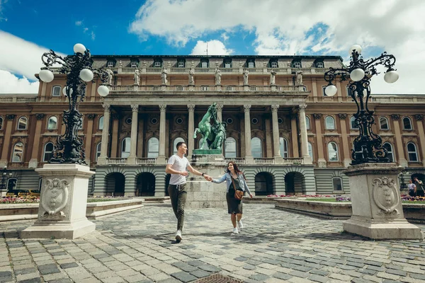 Mutlu bir şekilde konuşmak ve countryard Buda Castle Kraliyet Sarayı Budapeşte, Macaristan, el ele tutuşarak oldukça sevgi dolu çift yürümek. — Stok fotoğraf