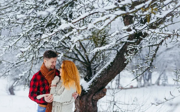 Casal feliz está rindo e abraçando durante sua caminhada ao longo da floresta nevada. Retrato de comprimento Hald . — Fotografia de Stock