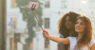 Selfie kullanarak fotoğraf çekerken komik surat çok ırklı kız yan görünüm neşeli güzel sopa.