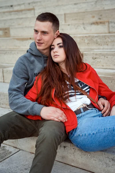 Yakın çekim portre sevimli genç çift elele ve Budapeşte, Macaristan'ın eski tarihi bina merdivenlerde oturan aşık. Kırmızı kafa kız sevgilisini eğilerek. — Stok fotoğraf