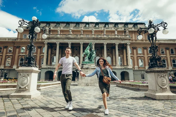 Buda Castle Kraliyet Sarayı Budapeşte, Macaristan, countryard boyunca yürürken el ele tutuşarak aşık oldukça genç çiftin tam uzunlukta görünümü. — Stok fotoğraf
