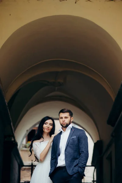 Outdoor bruiloft portret van de stijlvolle mooie paar jonggehuwden. De bruid is leunend op de schouders van de bruidegom. — Stockfoto